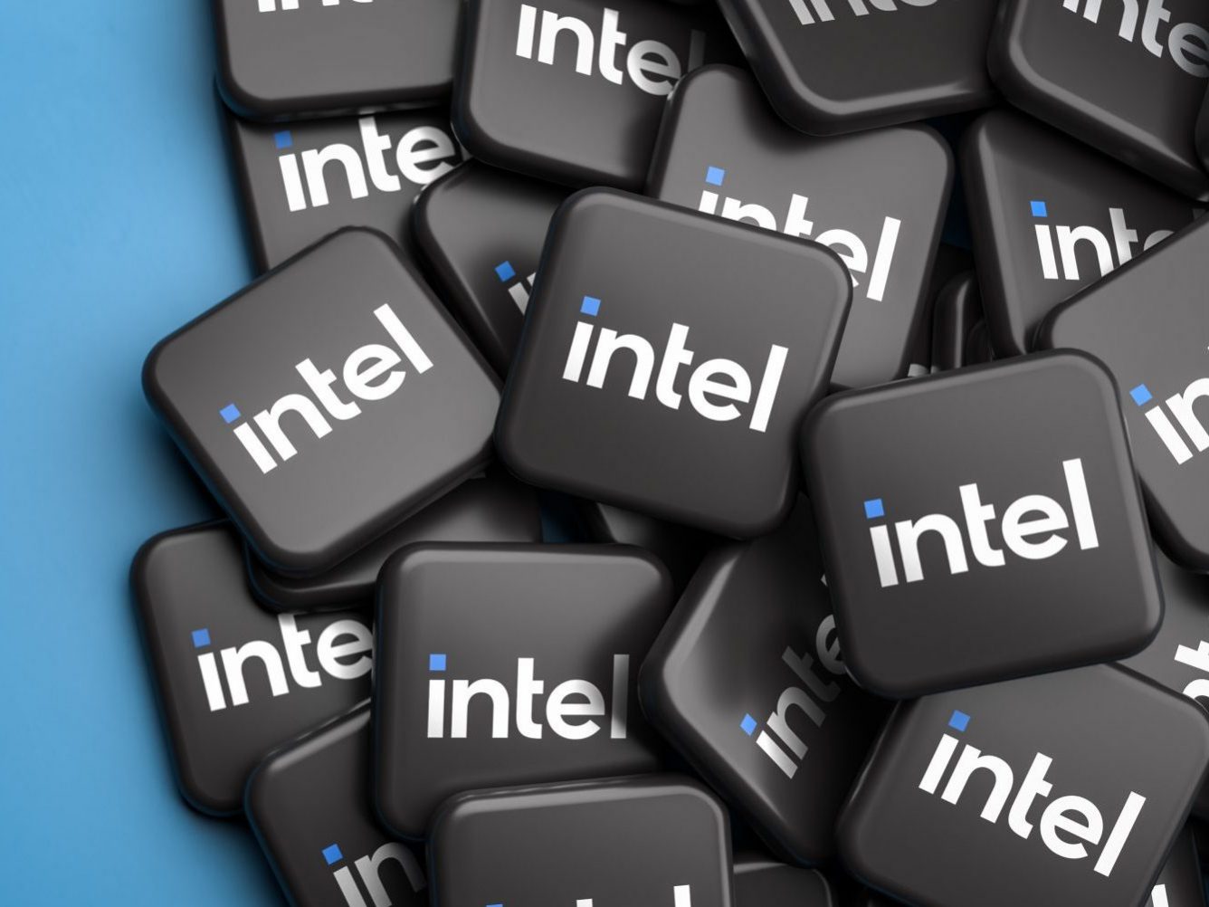 Logos of the tech company Intel on a heap on a table. Copy space. Web banner format.